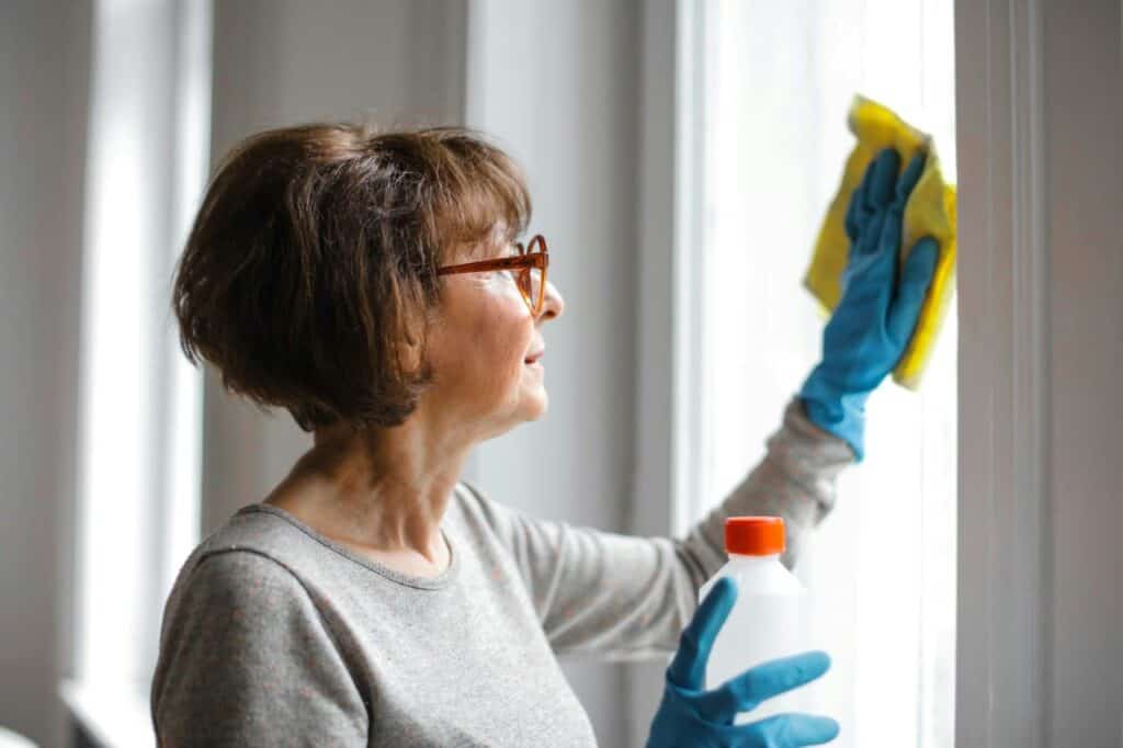 A woman cleaning her house window.